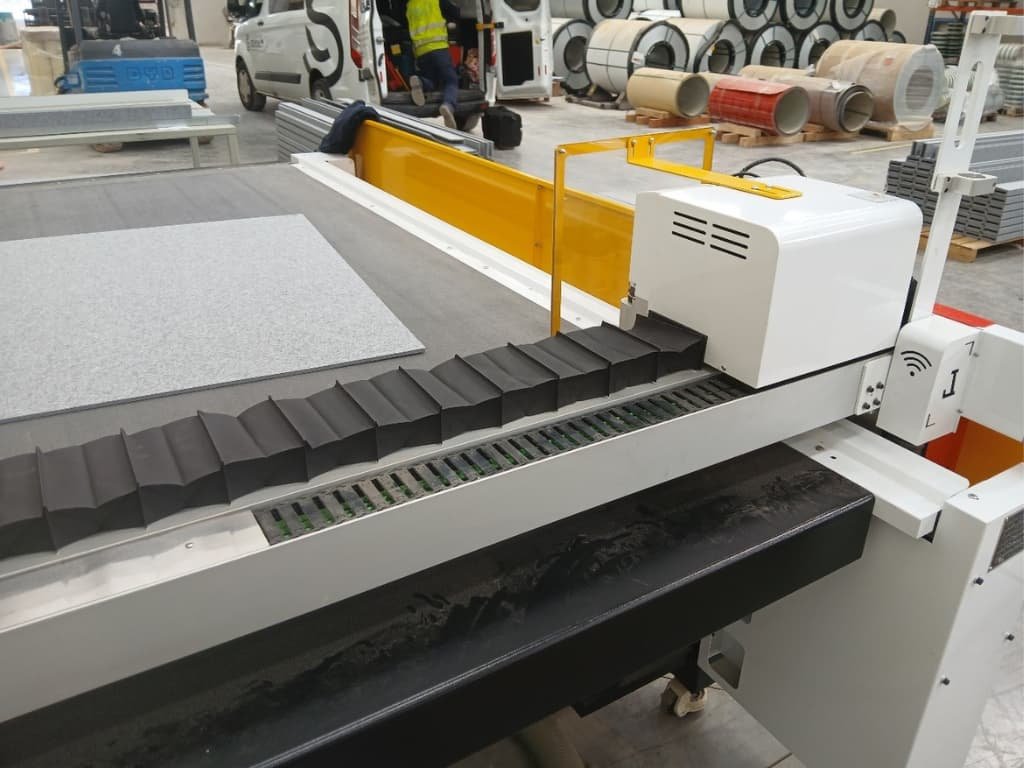 Detalle del fuelle instalado en el eje transversal de una cortadora CNC para proteger la transmisión